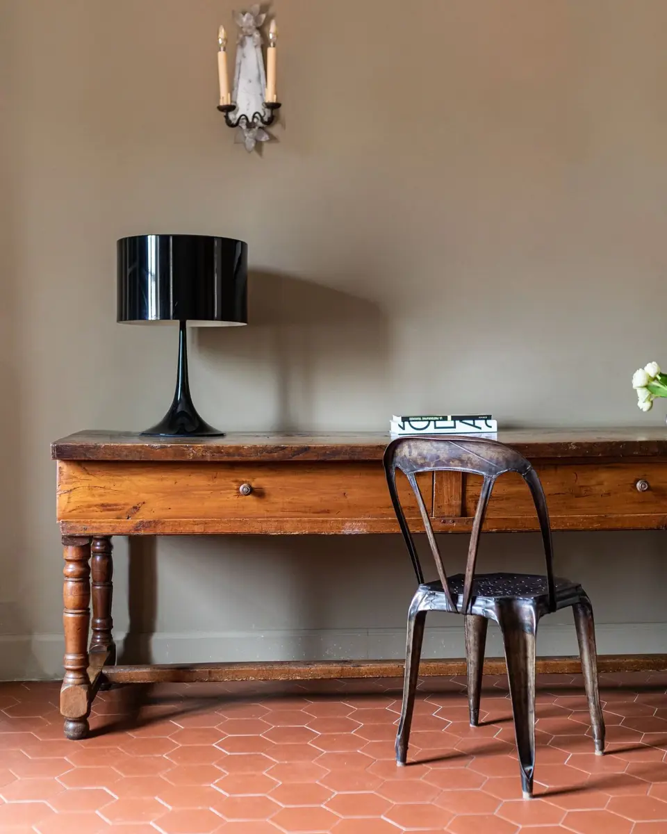 Lampe sur une table en bois avec une chaise en fer forgé.